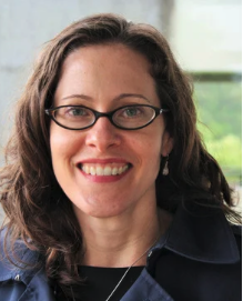 white woman with medium length brown hair, wears glasses